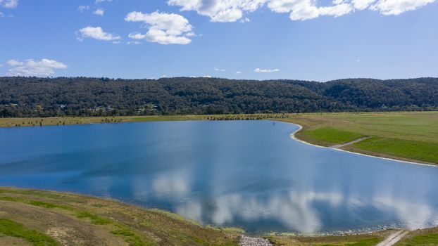 Aerial view of blue water at a rowing centre surrounded by green agricultural fields in regional Australia