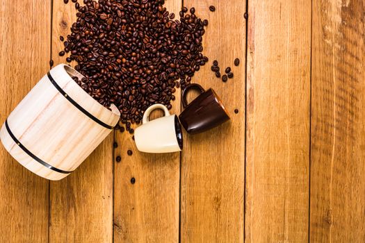 Cup of coffee, roasted coffee beans on wooden background, coffee wooden barrel top view, copy space for text, close up coffee photo