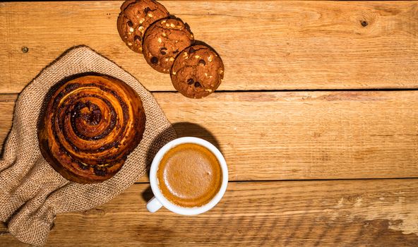 Fresh puff pastry on wooden table. Coffee, food and breakfast concept. Desserts, fresh pastries, biscuits and coffee. Top view and copy space