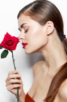 Woman with flower Sniffing red lips closed eyes bright makeup close-up