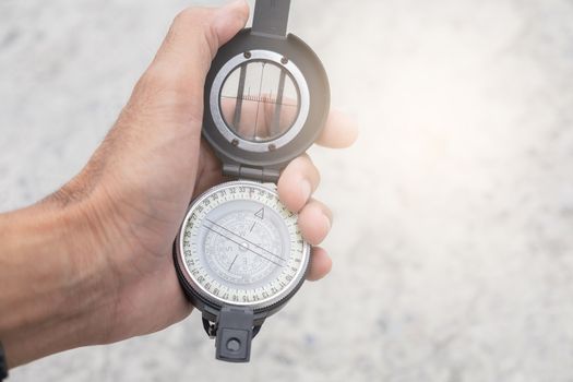 man holding compass on blurred background. for activity lifestyle outdoors freedom or travel tourism and inspiration backpacker alone tourist travel or navigator image.