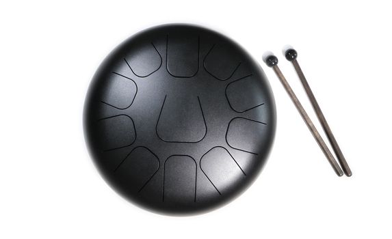 Top view of  steel tongue drum with drum sticks on white