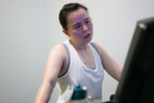 blur photo of tired woman jogger on treadmill
