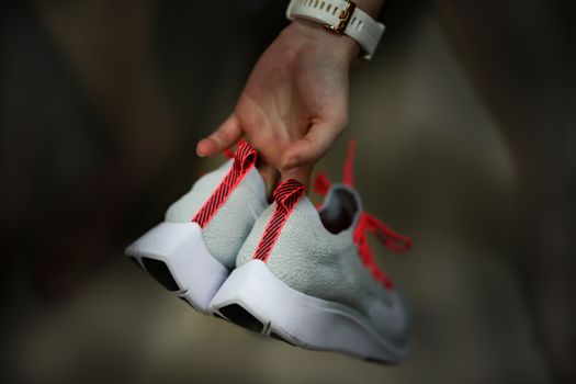 hand hold sport run footwear shoe on back side vie