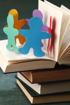 Paper people chain resting on the book