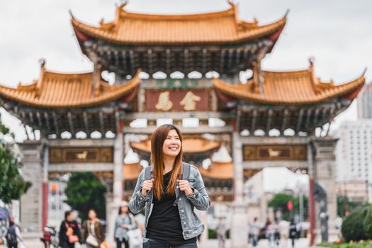 Asian traveler woman looking and sightseeing when travelling over the Jinbi square, Kunming, China, travel and tourism, china culture and traditional, famous place and landmark concept