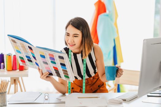 Young Asian designer woman choosing multicolor chart and holding coffee cup at workplace, small business startup, Business owner entrepreneur, modern freelance job lifestyle concept. asean people