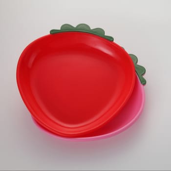 Red strawberry shaped plate on the white background