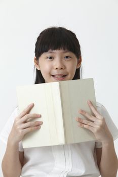 chinese girl holding a blank cover book looking at camera