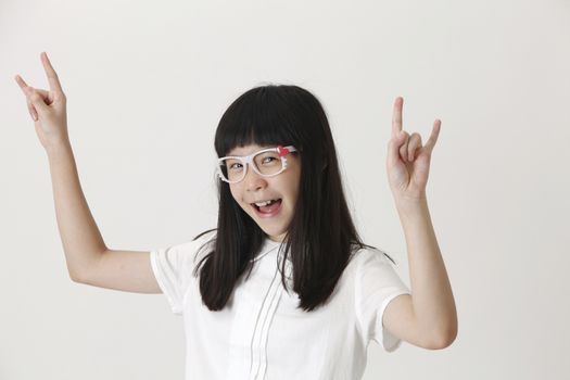 happy girl standing raising her arm with rock sign