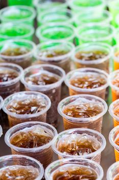 Multicolored drinks in clear plastic glasses