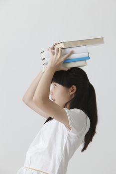 chinese girl balancing with books