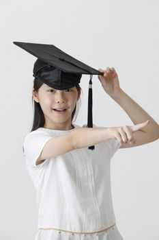 girl with the mortar board pointing