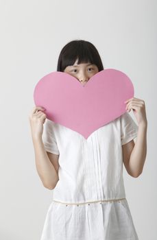 chinese girl holding a blank heart shape cardboard