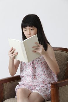 chinese girl sitting on the sofa reading book