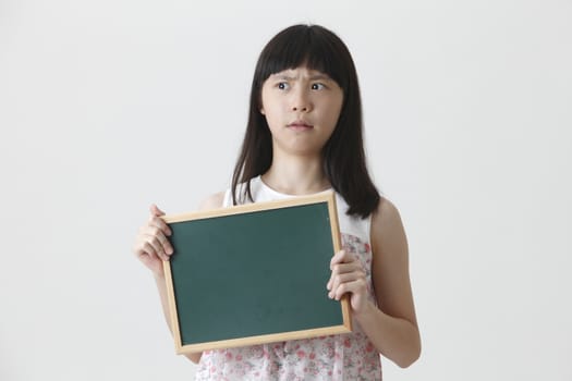 chinese girl holding a small chalk board with surprise