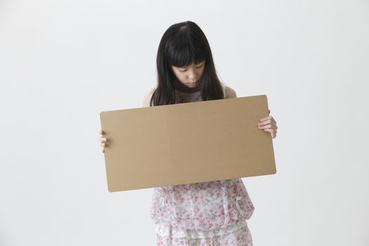 chinese girl holding and looking at brown message board