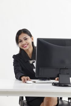 business woman sitting in front monitor looking at camera