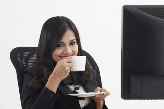 business woman sitting in front monitor having tea break