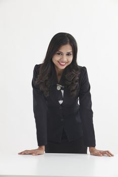 businesswoman standing behind of the desk confident