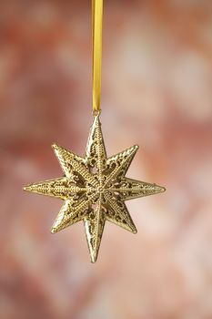 Christmas golden star on a on the warm background