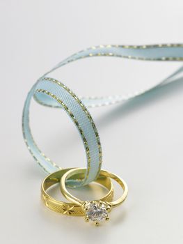 Wedding rings connected with green ribbon