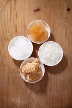 sugar types in white bowls, white wood table background