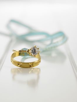 Wedding rings connected with green ribbon