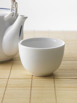 Japanese white tea pot on the bamboo mat