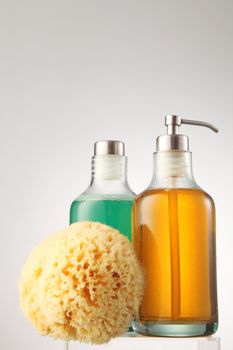 cleanser and shampoo in the glass container with natural bath sponge