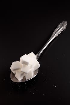 big or super size spoon with pile of cube white sugar