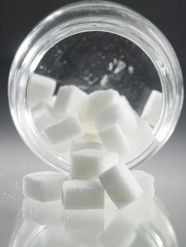 cube sugar pouring out from jar
