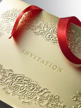 golden invitation card with ribbon