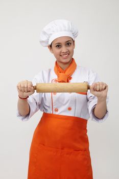 Portrait of a Indian woman with chef uniform holding rolling pin