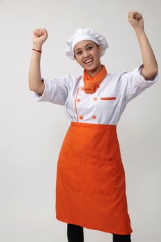 Portrait of a Indian woman with chef uniform with arm's up