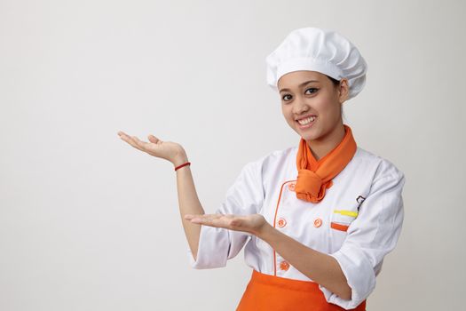 Portrait of young graceful woman dressed as a cook with cap