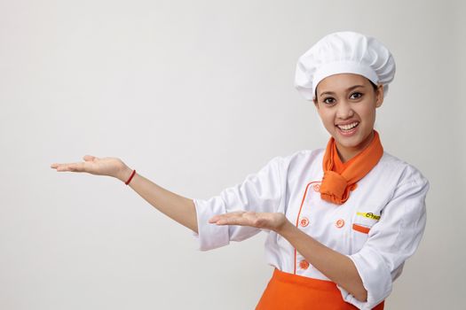 Portrait of young graceful woman dressed as a cook with cap