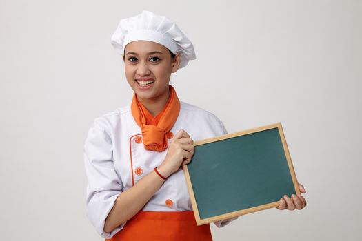Portrait of a Indian woman with chef uniform holding chalk board