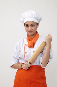 Portrait of a Indian woman with chef uniform holding rolling pin
