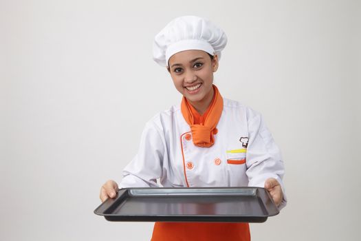 Portrait of a Indian woman with chef uniform holding an empty tray