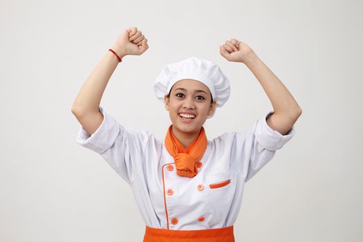 Portrait of a Indian woman with chef uniform with arm's up