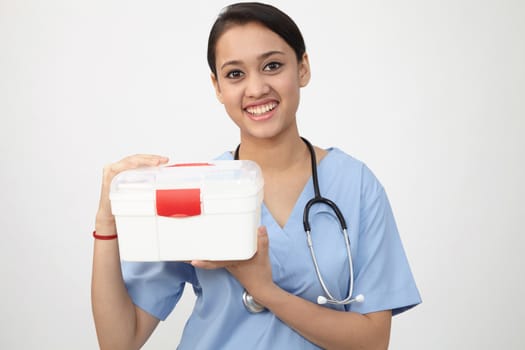 female nurse or doctor carrying a portable first aid kit isolated on white
