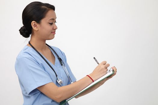 nurse writng on the clipboard that she is holding