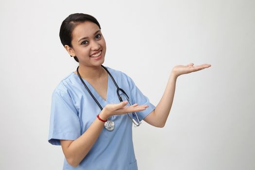 Young medical doctor woman presenting and showing copy space for product or text