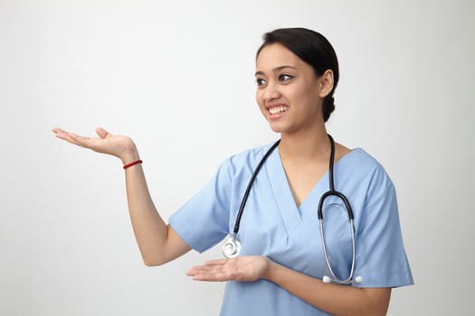 Young medical doctor woman presenting and showing copy space for product or text