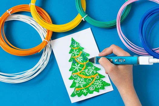 Child makes toys for Christmas tree with 3D pen. Original art project for children. New technology. DIY concept. Step by step photo instruction. Step 2. Draw toy