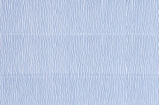 Light blue corrugated paper. Crepe paper texture. Light blue abstract paper background. Paper wrinkles, wavy surface