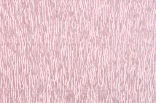 Pink corrugated paper. Crepe paper texture. Light pink abstract paper background. Paper wrinkles, wavy surface