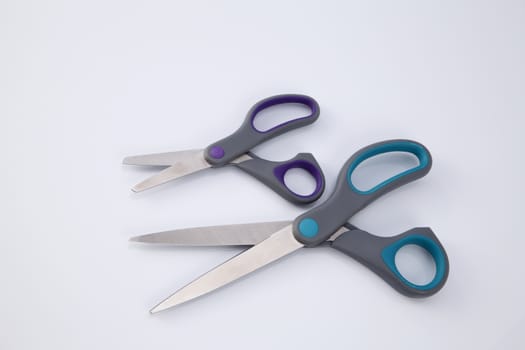 two pair of scissors which one big and small on the white background