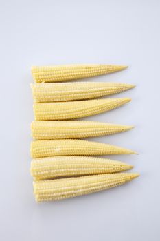 Baby corn on a white background, close-up